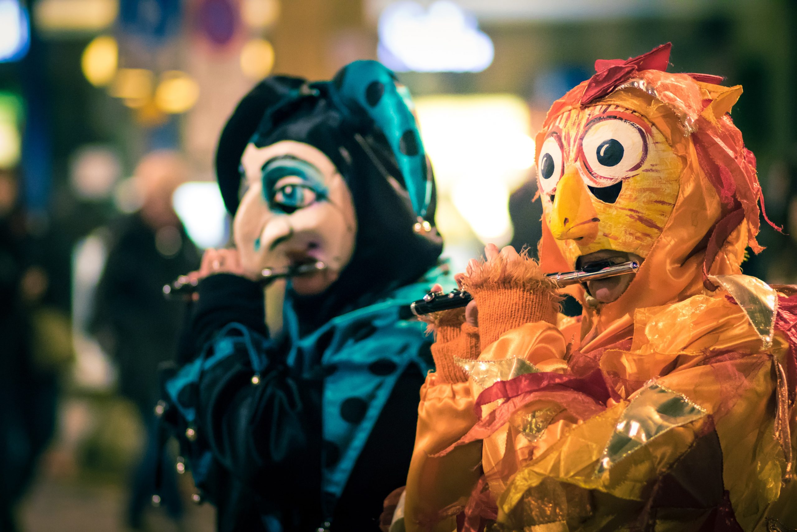 Zwei buntgekleidete, maskierte Menschen auf einem Karneval.